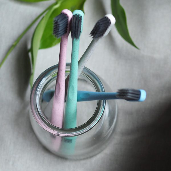 glass jar with four toothbrushes